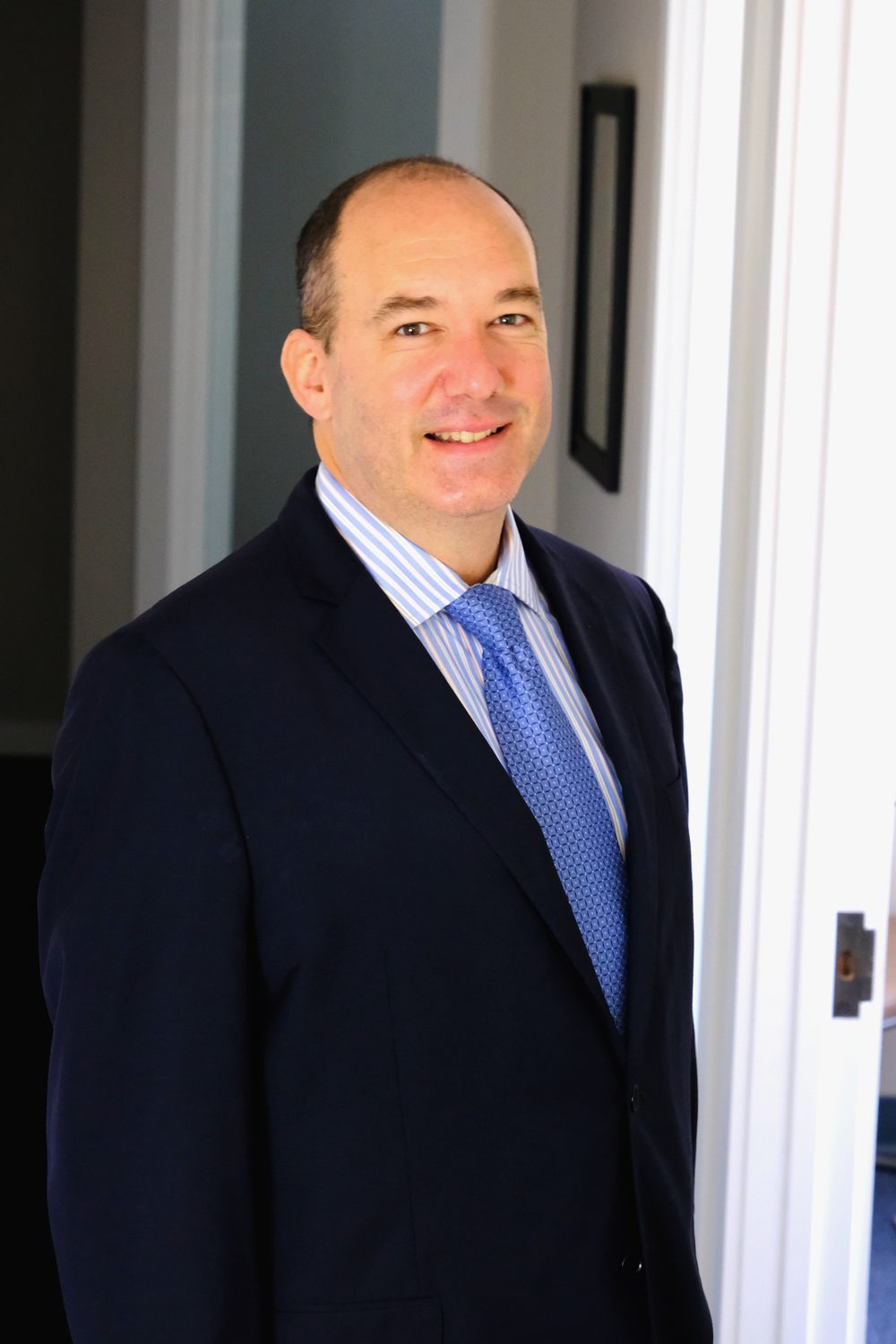 Drew F. Teti, founder of Teti Law, standing with arms crossed in a navy suit