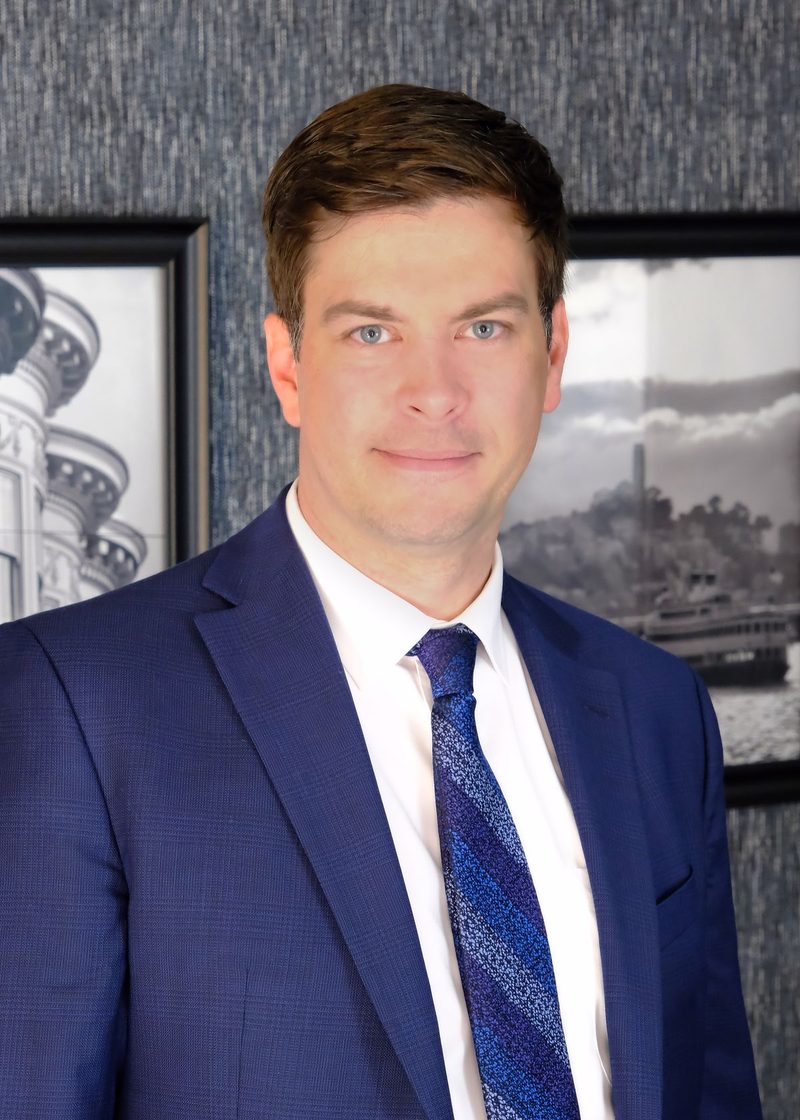 Dustin L. Collier, Of Counsel to Teti Law and founder of Collier Law Firm, in a blue suit
